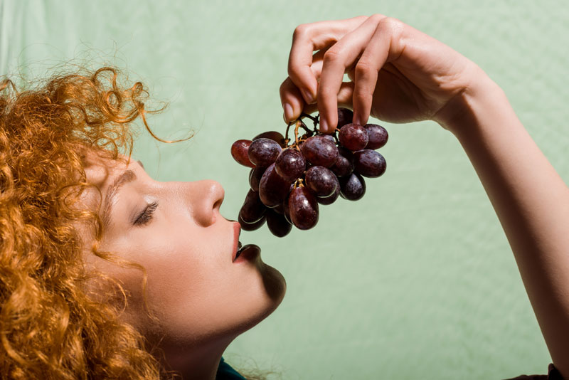 woman eating purple grapes
